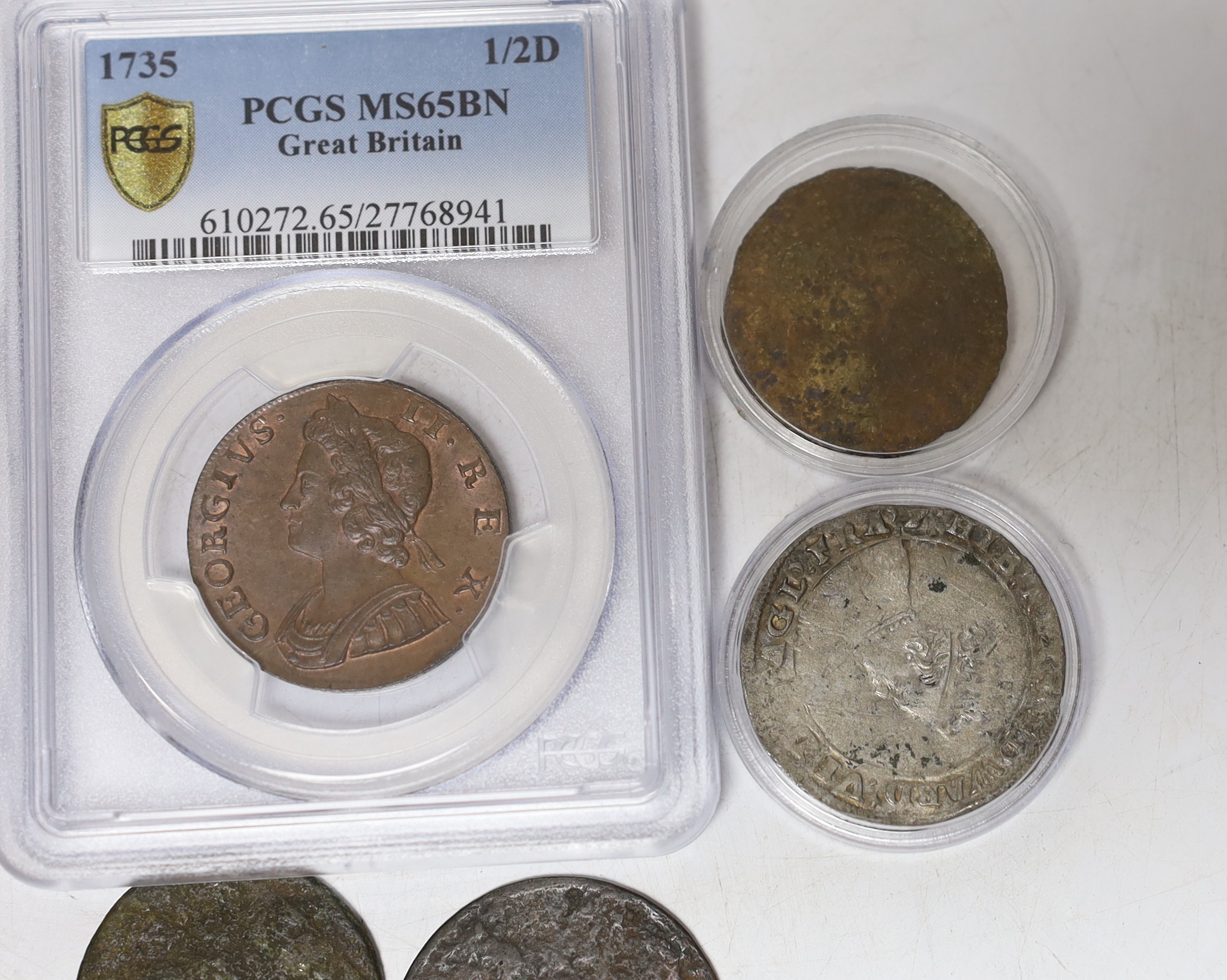 Seven coins including; a Charles II 1663 shilling, an Edward VI silver shilling, a George II 1735 half penny (PCGS graded MS65BN) together with four other coins